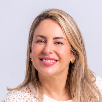 Retrato de Esther Rozalén, sonriente, con el pelo rubio por los hombros, mirando a cámara.